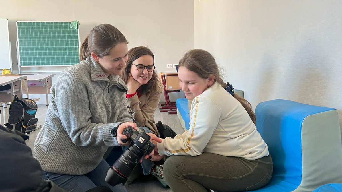 Her viser jeg en skoleelev i Bohdanivka i Ukraina bildene jeg har tatt av henne. På oppdrag for Panorama Nyheter dokumenterte jeg barnas skolehverdag i midlertidige lokaler etter at skolen deres brant ned under den russiske okkupasjonen. Foto: Katerynka Alieko.